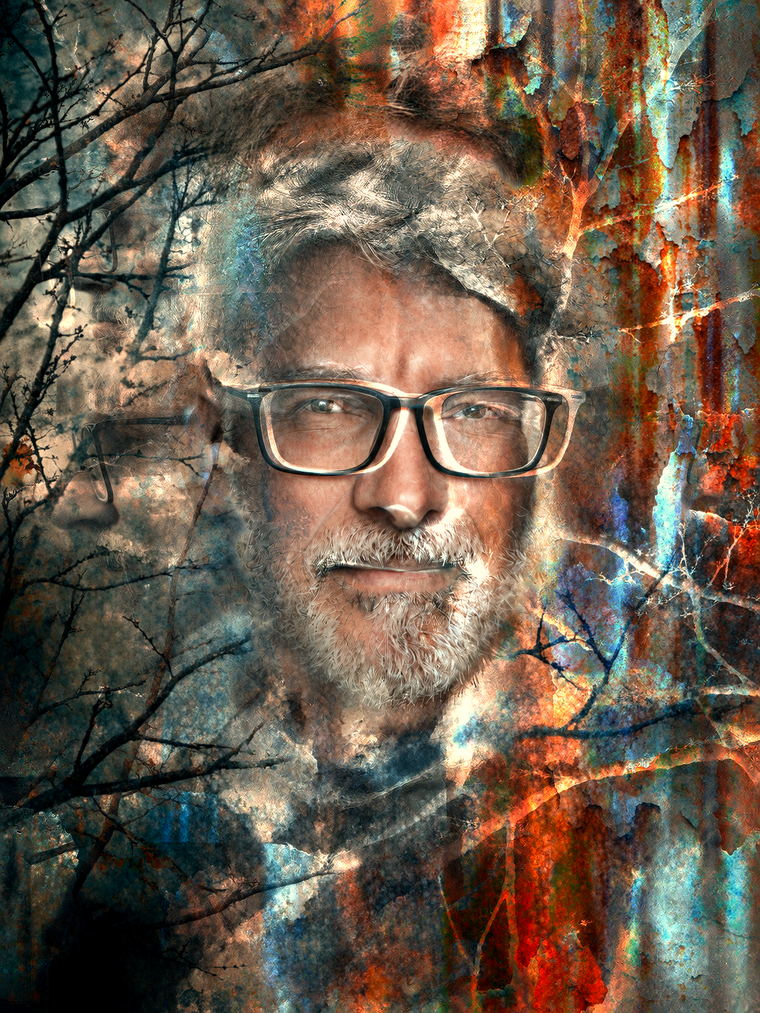 Portrait de Franke Feedcut en surimpression : un visage de face, lunettes et barbe blanche, fondu dans des branches nues et un mur de rouille aux éclats bleus.